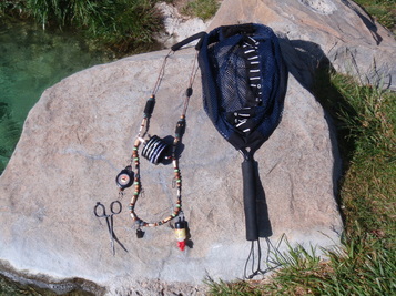 Fly fishing lanyard with tools and net attached.